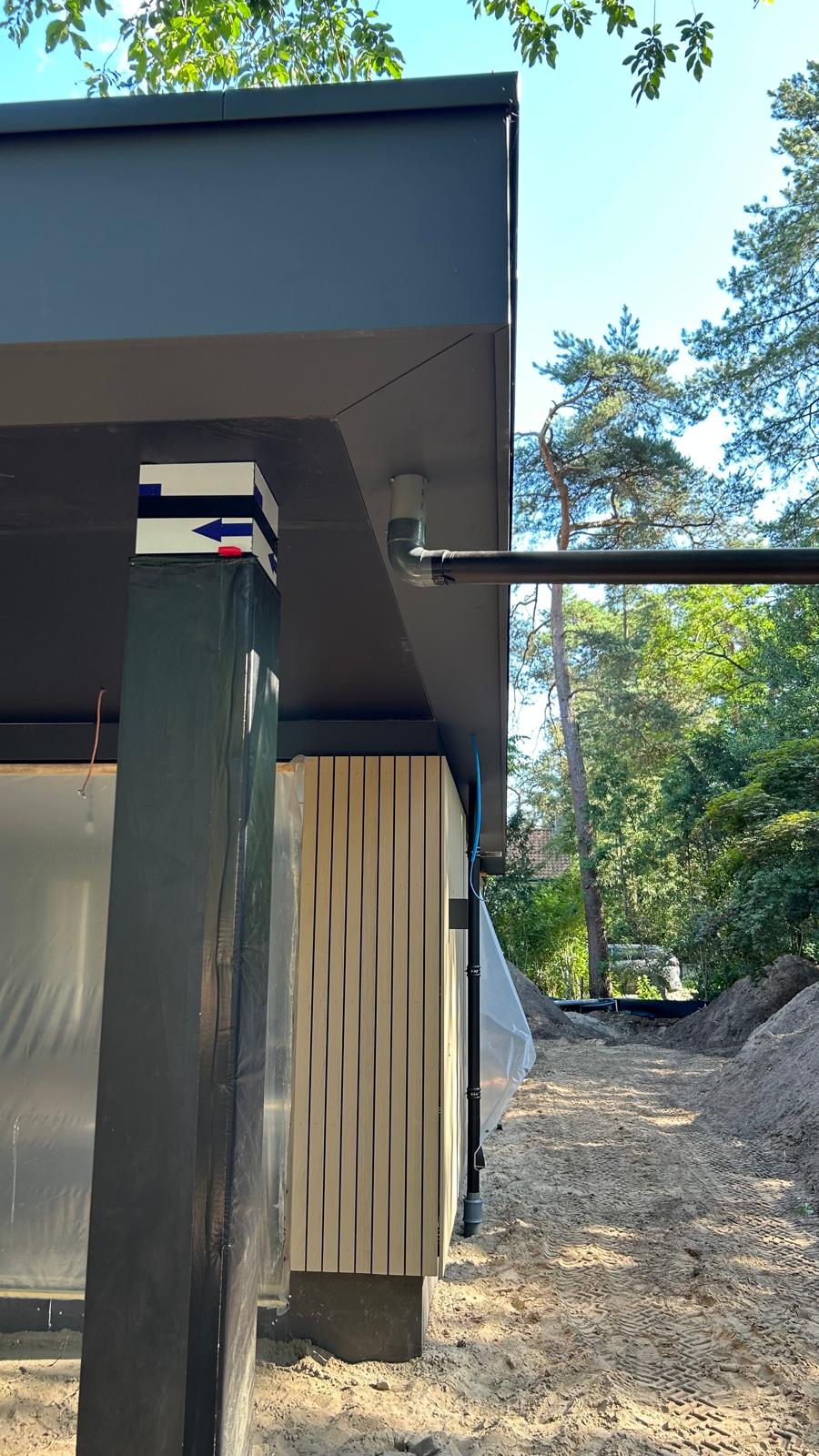 Detail van een donker overstek en kolom bij de woning in Maarn